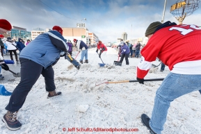 Volunteers shovels snow back onto the trail at a street crossing on 4th avenue during the cermonial start day of Iditarod 2015 in Anchorage, Alaska. Saturday March 7, 2015(C) Jeff Schultz/SchultzPhoto.com - ALL RIGHTS RESERVED DUPLICATION  PROHIBITED  WITHOUT  PERMISSION