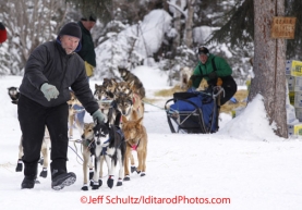 Thursday March, 2012   An Ophir volunteer helps Colleen Robertia leave the checkpoint.   Iditarod 2012.