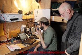 Volunteer comms Mike Holland (left) and Grant Jacobson man the comm equipment in their home-away-from-home 10 x12  wall-tent/sleeping quarters at the halfway checkpoint of Iditarod on Friday March 8, 2013.Iditarod Sled Dog Race 2013Photo by Jeff Schultz copyright 2013 DO NOT REPRODUCE WITHOUT PERMISSION