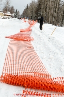 Volunteers set up snow fencing right down the center line of Broadmoore street on Sunday March 8, 2015 the day before the official start of Iditarod 2015(C) Jeff Schultz/SchultzPhoto.com - ALL RIGHTS RESERVED DUPLICATION  PROHIBITED  WITHOUT  PERMISSION