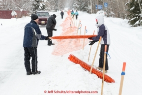 Volunteers set up snow fencing right down the center line of Broadmoore street on Sunday March 8, 2015 the day before the official start of Iditarod 2015(C) Jeff Schultz/SchultzPhoto.com - ALL RIGHTS RESERVED DUPLICATION  PROHIBITED  WITHOUT  PERMISSION