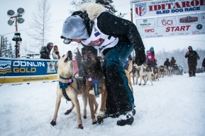 Rookie Riley Dyche with bib number 48 of Fairbanks, Alaska takes a moment with his team at the starting line before heading out to Nome.