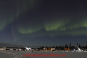 Friday March 9, 2012  Northern lights grace the sky over the    half-way checkpoint at Cripple while mushers tend to their dogs.   Iditarod 2012.