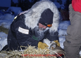 Friday March 9, 2012    Musher Scott Jansen cuddles with one of his dogs in the early morning at the half-way checkpoint at Cripple.   Iditarod 2012.