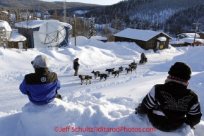 Friday March 9, 2012   Nine-year old Sheldon Albert (L)  and Vernon Albert watch Martin Buser run up the road as he arrives in the Yukon River village of Ruby, Alaska. Iditarod 2012.