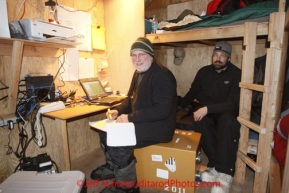 Friday March 9, 2012   Communications volunteers Grant Jacobson and Mike Holland move dog and people traffic across the internet via a GCI internet connection in their 10'x 8' work and sleeping area at the half-way checkpoint at Cripple.   Iditarod 2012.