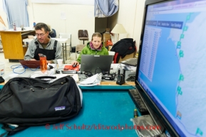 Volunteer Comms Keri Hull works the computer with Iditarod insider Joe Runyan at Unalakleet on Sunday, March 9, during the Iditarod Sled Dog Race 2014.PHOTO (c) BY JEFF SCHULTZ/IditarodPhotos.com -- REPRODUCTION PROHIBITED WITHOUT PERMISSION