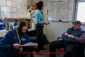 Logistics coordinators Teri Paton & Debbie Miller work with chief pilot Bert Hanson to coordinate flights at Unalakleet on Sunday, March 9, during the Iditarod Sled Dog Race 2014.PHOTO (c) BY JEFF SCHULTZ/IditarodPhotos.com -- REPRODUCTION PROHIBITED WITHOUT PERMISSION