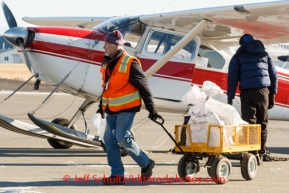 Logistics support Jay Holtan unloads an aircraft at Unalakleet  on Sunday, March 9, during the Iditarod Sled Dog Race 2014.PHOTO (c) BY JEFF SCHULTZ/IditarodPhotos.com -- REPRODUCTION PROHIBITED WITHOUT PERMISSION