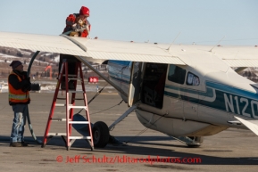 Jay Holtan helps pilot Diana Moroney fuel her plane at Unalakleet on Sunday, March 9, during the Iditarod Sled Dog Race 2014.PHOTO (c) BY JEFF SCHULTZ/IditarodPhotos.com -- REPRODUCTION PROHIBITED WITHOUT PERMISSION