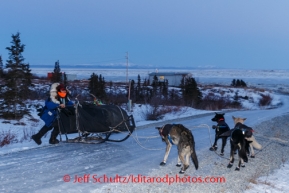 Martin Buser manhandles his sled as he crosses a road with glare ice on his way out of Koyuk on Sunday, March 9, during the Iditarod Sled Dog Race 2014.PHOTO (c) BY JEFF SCHULTZ/IditarodPhotos.com -- REPRODUCTION PROHIBITED WITHOUT PERMISSION