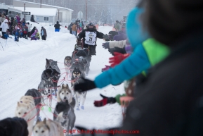 Curt Perano gives high-fives to the crowd lining Broadmoore street shortly after leaving the Fairbanks start line on Monday March 9 during the 2015 Iditarod.(C) Jeff Schultz/SchultzPhoto.com - ALL RIGHTS RESERVED DUPLICATION  PROHIBITED  WITHOUT  PERMISSION