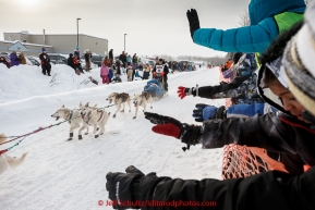 Ellen Halverson is greeted as she runs down Broadmoore street shortly after leaving the start line in Fairbanks on Monday March 9 during the 2015 Iditarod. (C) Jeff Schultz/SchultzPhoto.com - ALL RIGHTS RESERVED DUPLICATION  PROHIBITED  WITHOUT  PERMISSION