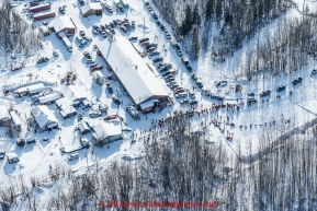 Teams run past and park at the community center  at the first checkpoint in Nenana on March 9th, 2015 during the 2015 Iditarod.(C) Jeff Schultz/SchultzPhoto.com - ALL RIGHTS RESERVED DUPLICATION  PROHIBITED  WITHOUT  PERMISSION