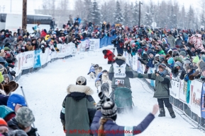 Lachlan Clarke of Buena Vista, Colorado, giving a high-five to one of the fans at the offical start of the 2015 Iditarod in Fairbanks, Alaska.(C) Jeff Schultz/SchultzPhoto.com - ALL RIGHTS RESERVED DUPLICATION  PROHIBITED  WITHOUT  PERMISSION