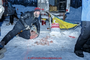 Peter Reuters chops food up for dogs at the offical start of the 2015 Iditarod in Fairbanks, Alaska.(C) Jeff Schultz/SchultzPhoto.com - ALL RIGHTS RESERVED DUPLICATION  PROHIBITED  WITHOUT  PERMISSION