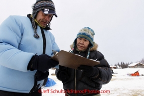 Tuesday March 6, 2012 Nikolai resident Marty Runkle checks in Martin Buser at the checkpoint, Iditarod 2012.