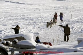 Sunday March 11, 2012 Sigrid Ekran arrives in the coastal village of Unalakleet, and is directed to her parking area by volunteer checkers.  Iditarod 2012.
