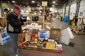 At the Airland Transport's sort facility, volunteers sort and package people food & accompanying supplies for the trail volunteers to eat during the race at the 20+ checkpoints on Friday February 14, 2014.  Iditarod Sled Dog Race 2014PHOTO BY JEFF SCHULTZ/IDITARODPHOTOS.COM  USE ONLY WITH PERMISSION