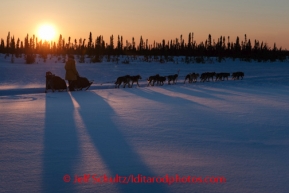 Rookie musher Katherine Keith runs on the trail on the way to  the Cripple checkpoint at sunset, Thursday, March 6, during the Iditarod Sled Dog Race 2014.PHOTO (c) BY JEFF SCHULTZ/IditarodPhotos.com -- REPRODUCTION PROHIBITED WITHOUT PERMISSION