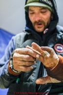 Lance Mackey shows off his frozen hands at the Tanana checkpoint on Wednesday morning  March 11th during the 2015 Iditarod.(C) Jeff Schultz/SchultzPhoto.com - ALL RIGHTS RESERVED DUPLICATION  PROHIBITED  WITHOUT  PERMISSION