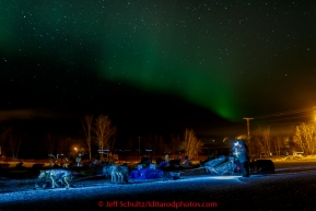 Teams rest on the baseball field as the Northern Lights play overhead in the morning at the Huslia checkpoint on Saturday  March 14, 2015 during Iditarod 2015.  (C) Jeff Schultz/SchultzPhoto.com - ALL RIGHTS RESERVED DUPLICATION  PROHIBITED  WITHOUT  PERMISSION