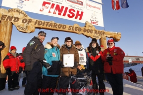 Sunday March 18, 2012    Dan Seavey, mushing to celebrate the 100th anniversary of the historic Iditarod Trail poses with the board members of National Historic Trail at the finish line in Nome. Iditarod 2012.