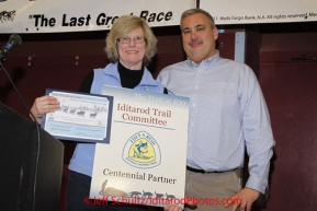 Sunday March 18, 2012  Iditarod National Historic Trail Alliance president Judy Bittner (L) presents a Centennnial Partner commendation to Iditarod Trail Committee President Andy Baker at the musher's finisher banquet in Nome after Iditarod 2012.