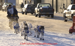 Sunday March 18, 2012    Dan Seavey, mushing to celebrate the 100th anniversary of the historic Iditarod Trail  runs down Front Street nearing the finish line in Nome. Iditarod 2012.