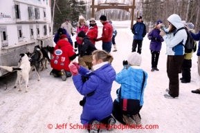 People take photos of volunteers performing mandatory vet checks on Lance Mackey's sled dogs in Wasilla Wednesday, Feb. 27, 2013.