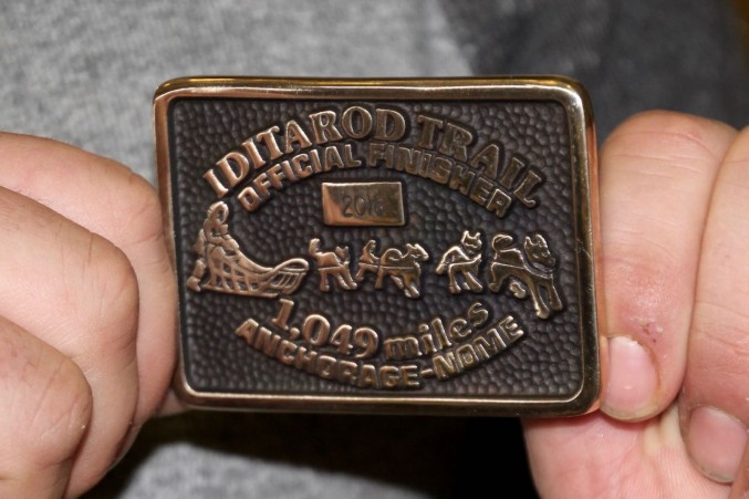 Patrick Beall displays the Belt Buckle awarded to rookies in Nome