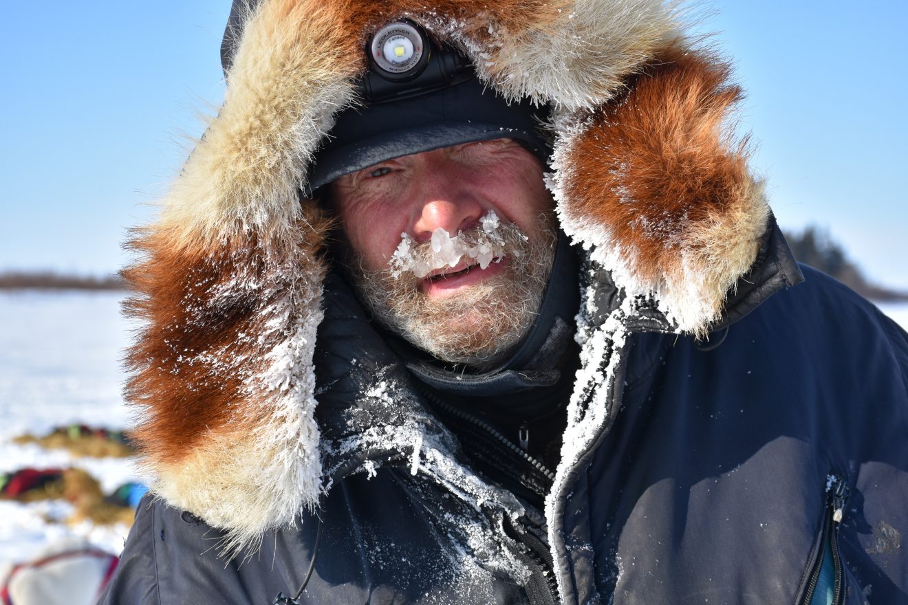 Jim Lanier scratches at Rainy Pass checkpoint – Iditarod