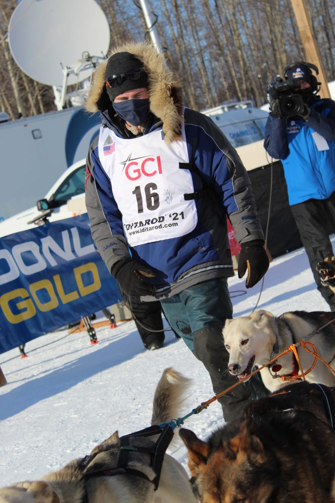 Veteran Iditarod musher Riley Dyche scratches at Iditarod checkpoint